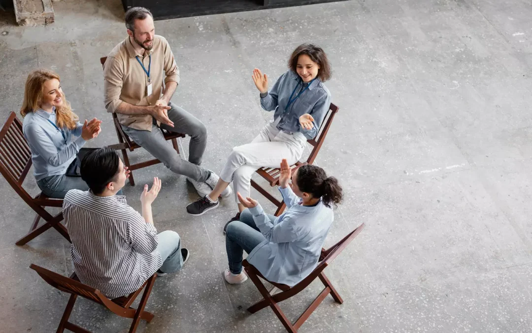 Uczestnicy warsztatów siedzący na krzesłach